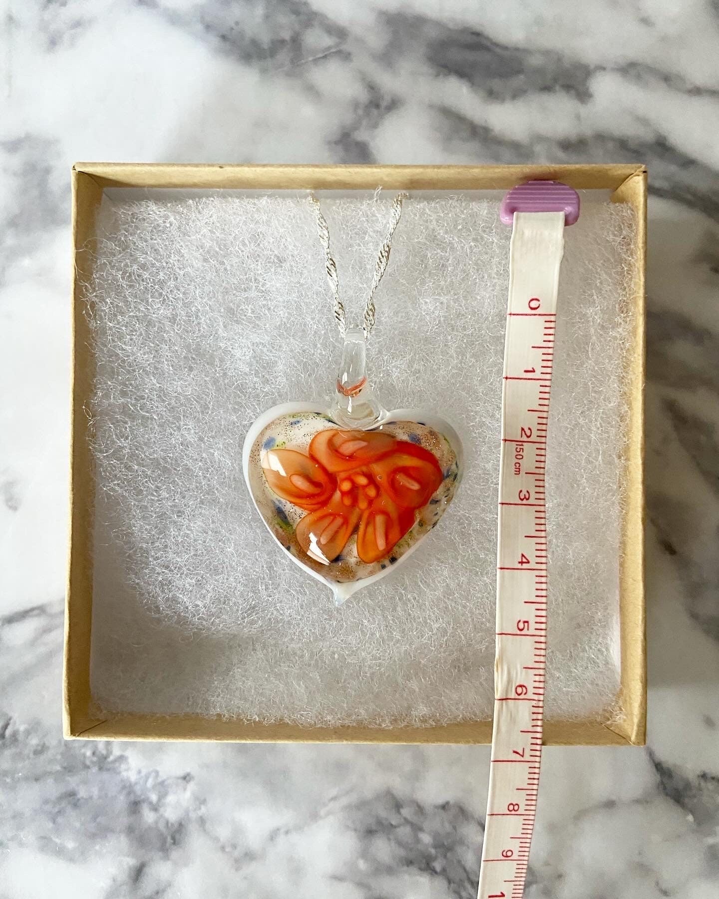 Large orange calla lily floral with gold glitter on white Murano style heart glass necklace