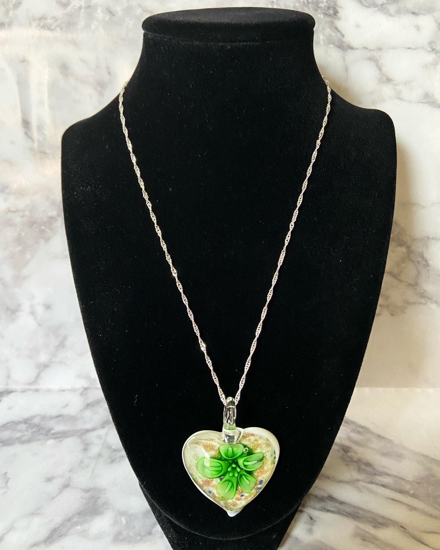 Large green calla lily floral with gold glitter on white Murano style heart glass necklace