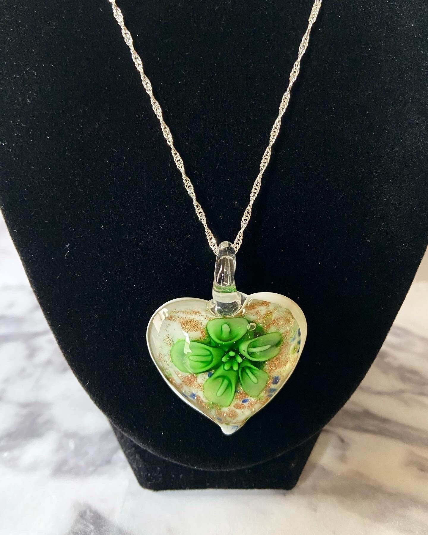 Large green calla lily floral with gold glitter on white Murano style heart glass necklace