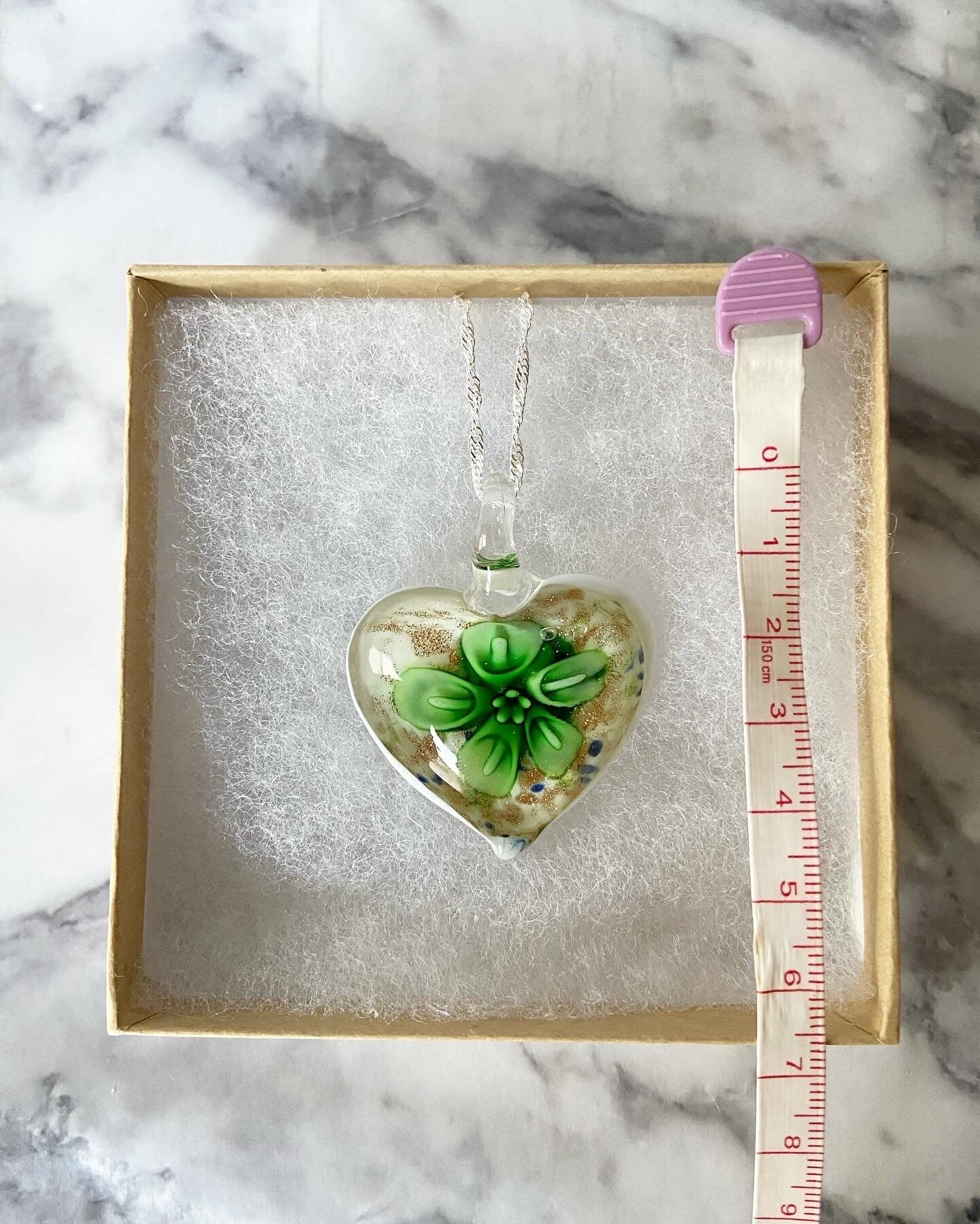 Large green calla lily floral with gold glitter on white Murano style heart glass necklace